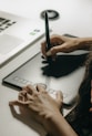 a woman sitting at a desk writing on a laptop