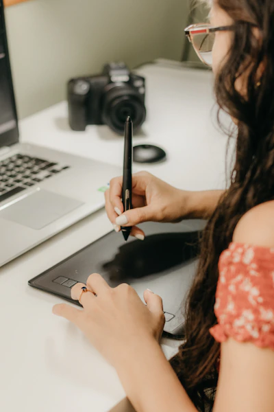 a woman sitting at a desk using a cell phone