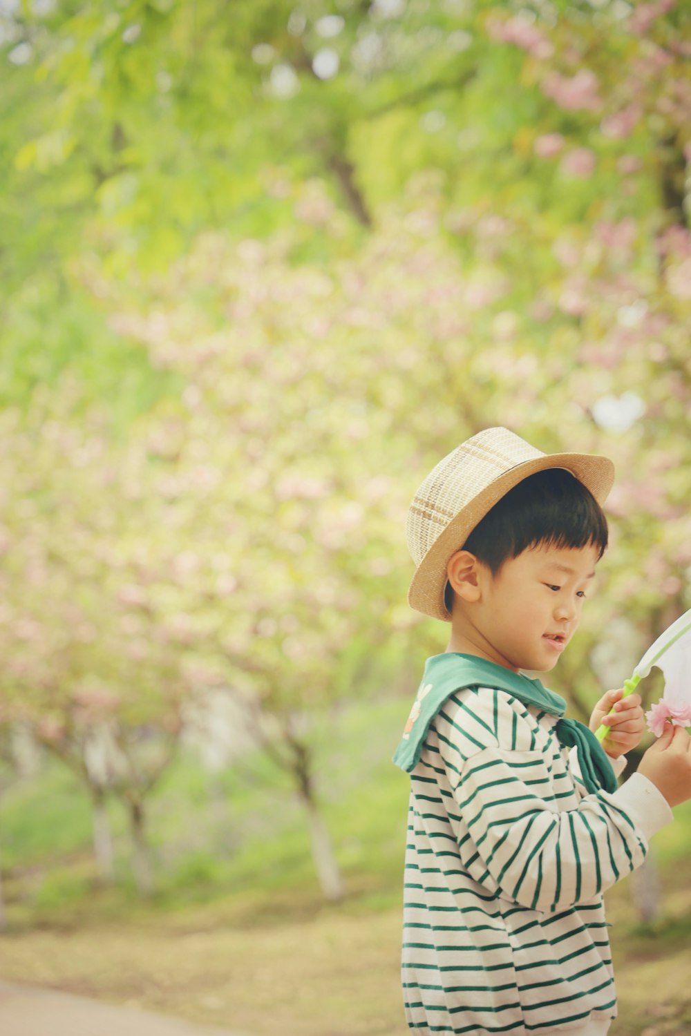 a young boy holding an umbrella in a park