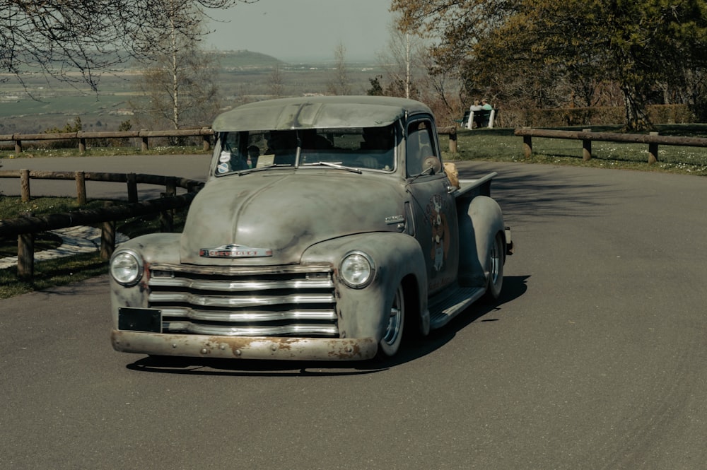 an old truck is parked on the side of the road