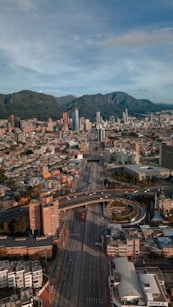 an aerial view of a city with mountains in the background