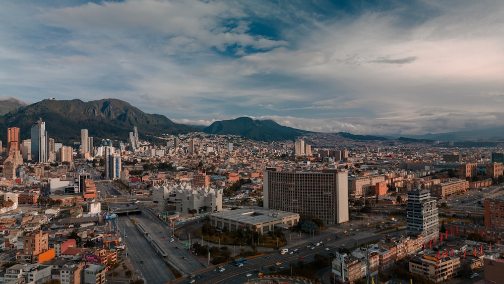 an aerial view of a city with mountains in the background