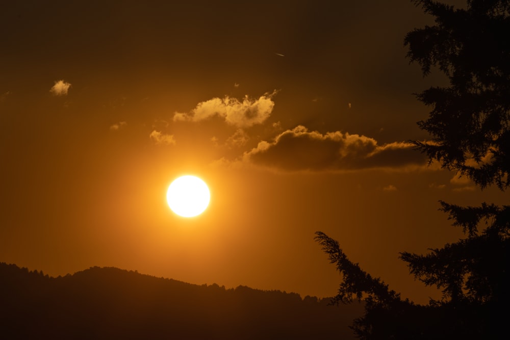 the sun is setting over a mountain range