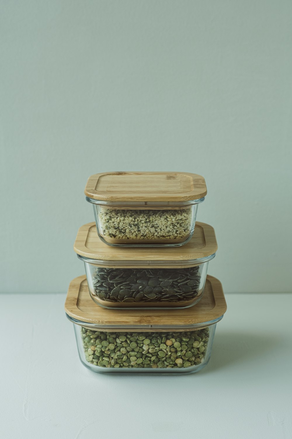 a stack of three glass containers filled with food