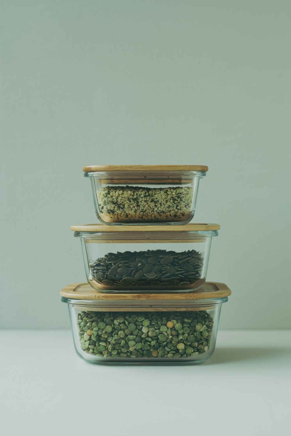 tre contenitori di vetro riempiti con diversi tipi di cibo