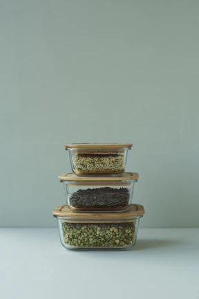 three glass containers filled with food on top of a table