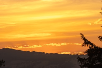 A scenic view from the motorhome window showing rolling hills and a golden sunset.