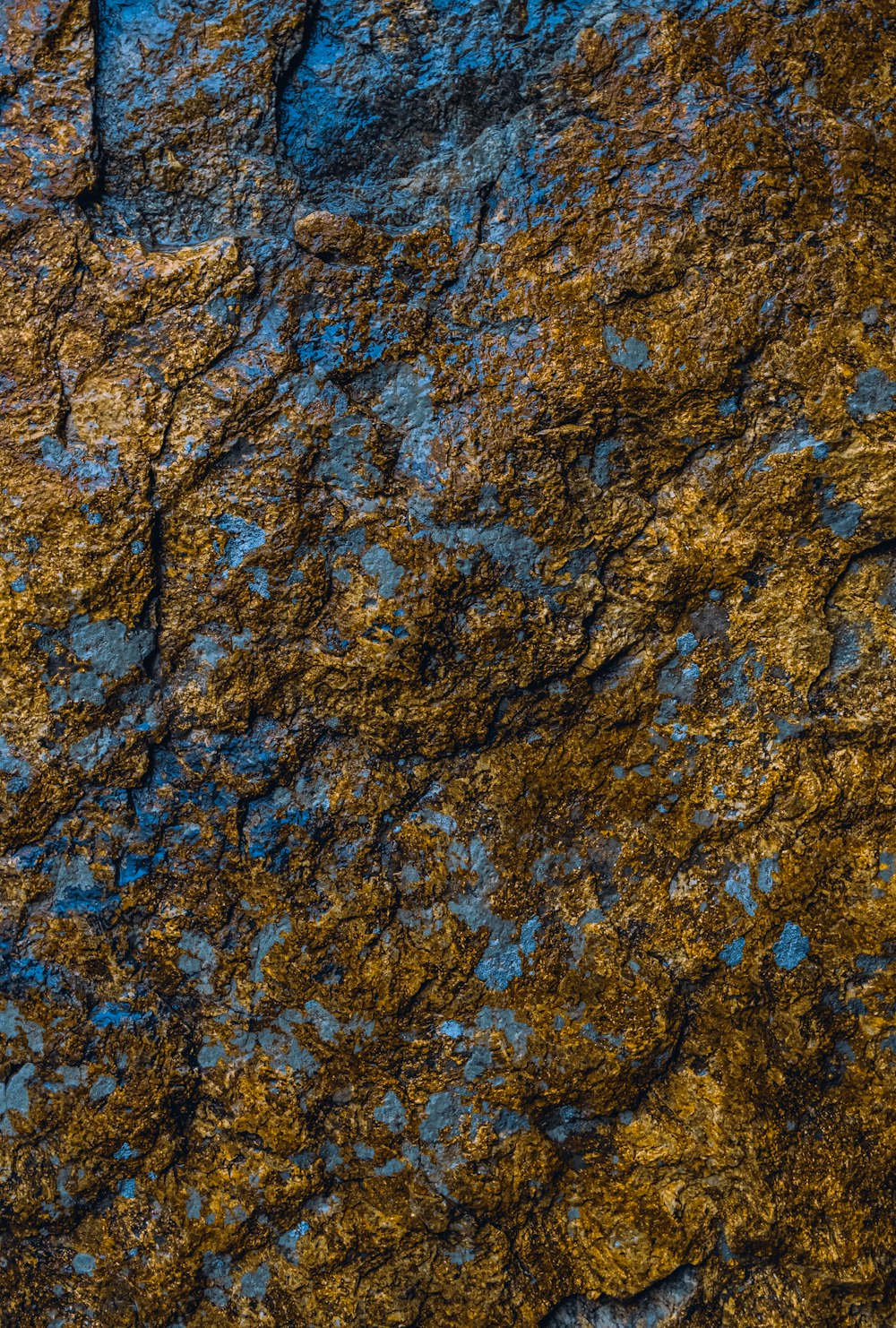 a close up of a rock face with a blue sky in the background