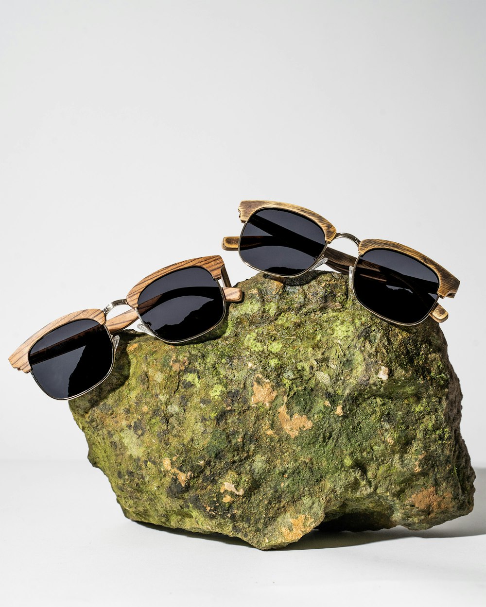 three pairs of sunglasses sitting on top of a rock