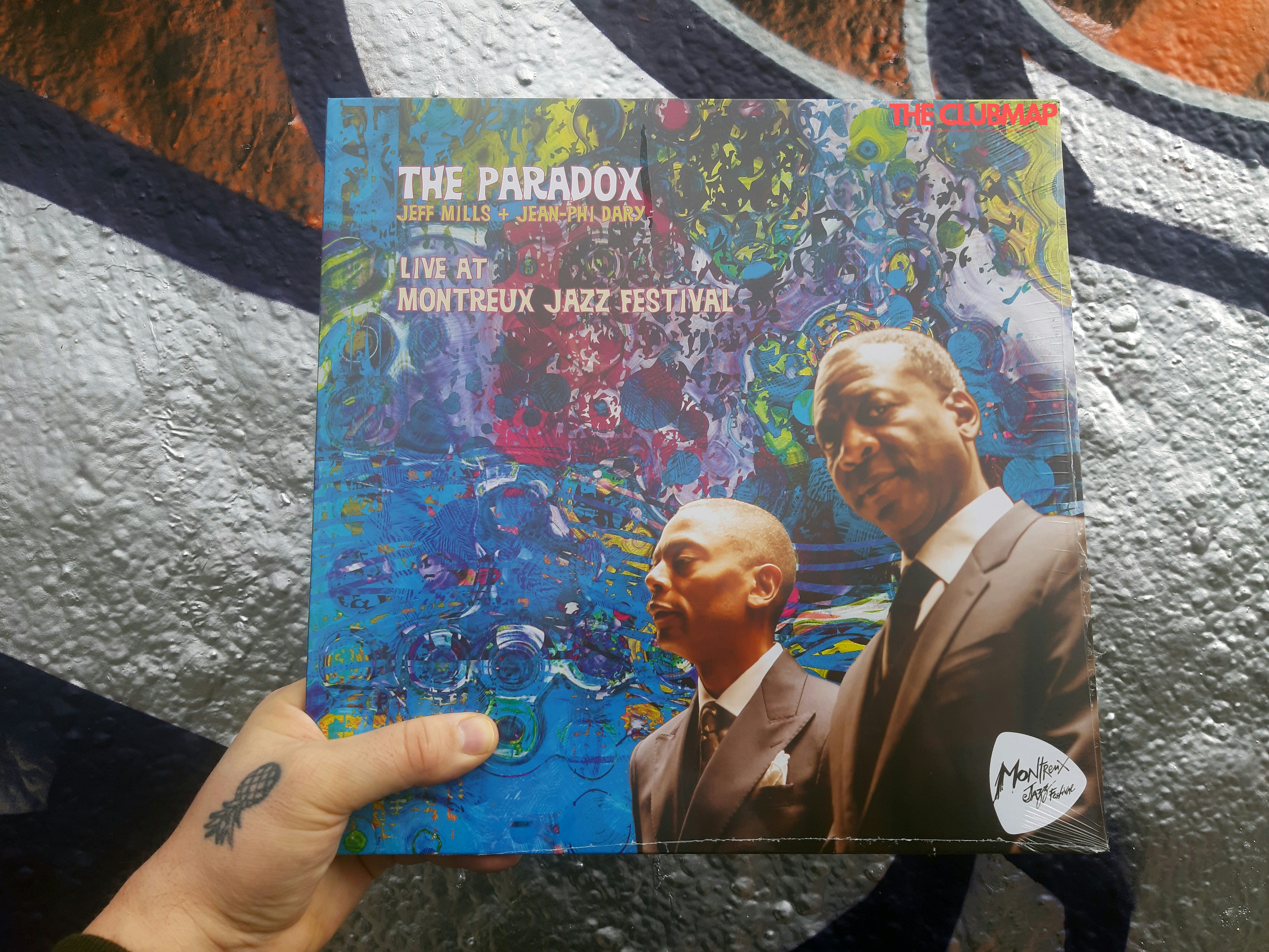 a person holding up a book in front of a graffiti wall