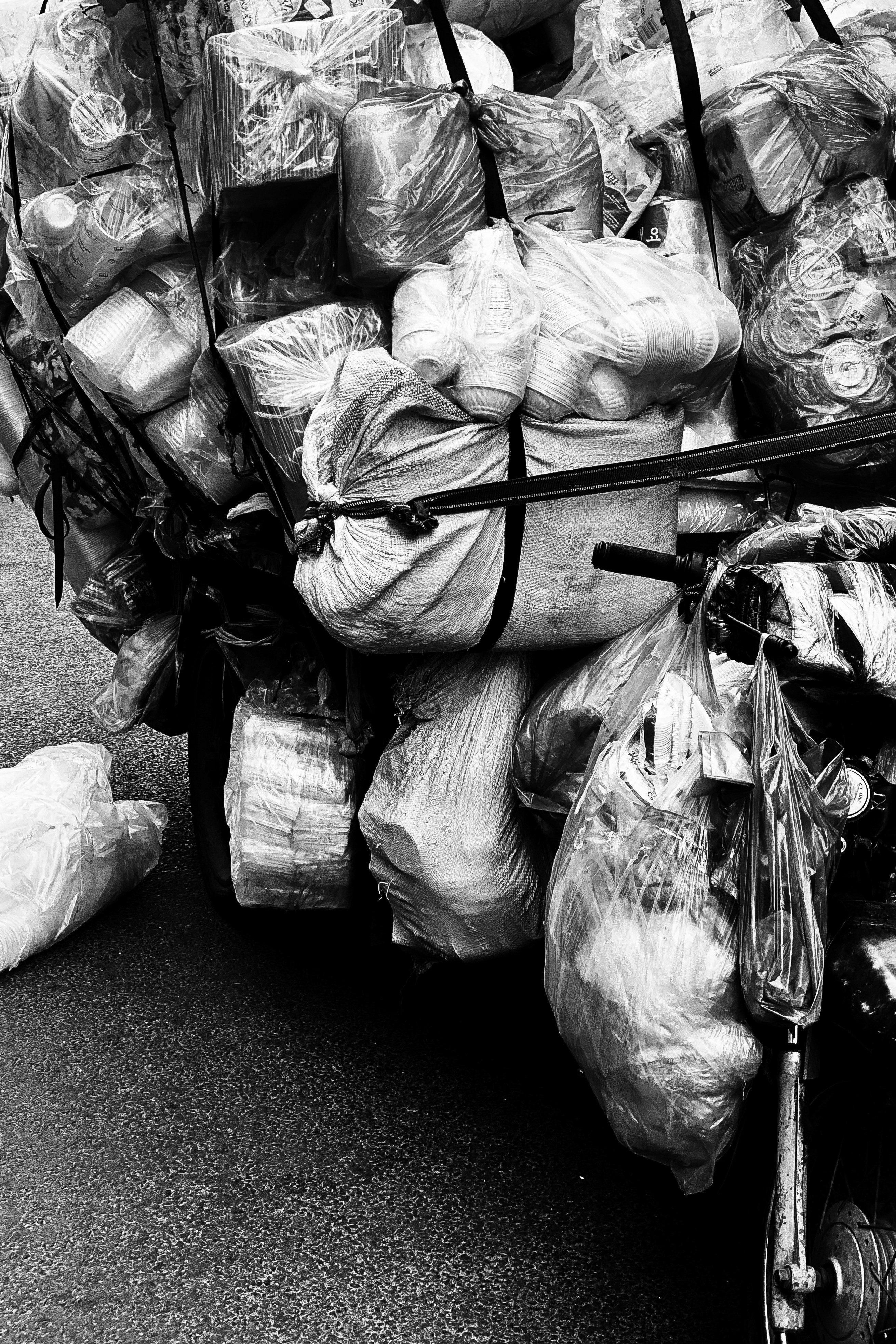 Motorcycle being carefully loaded onto a transport truck with protective wrapping, industrial setting