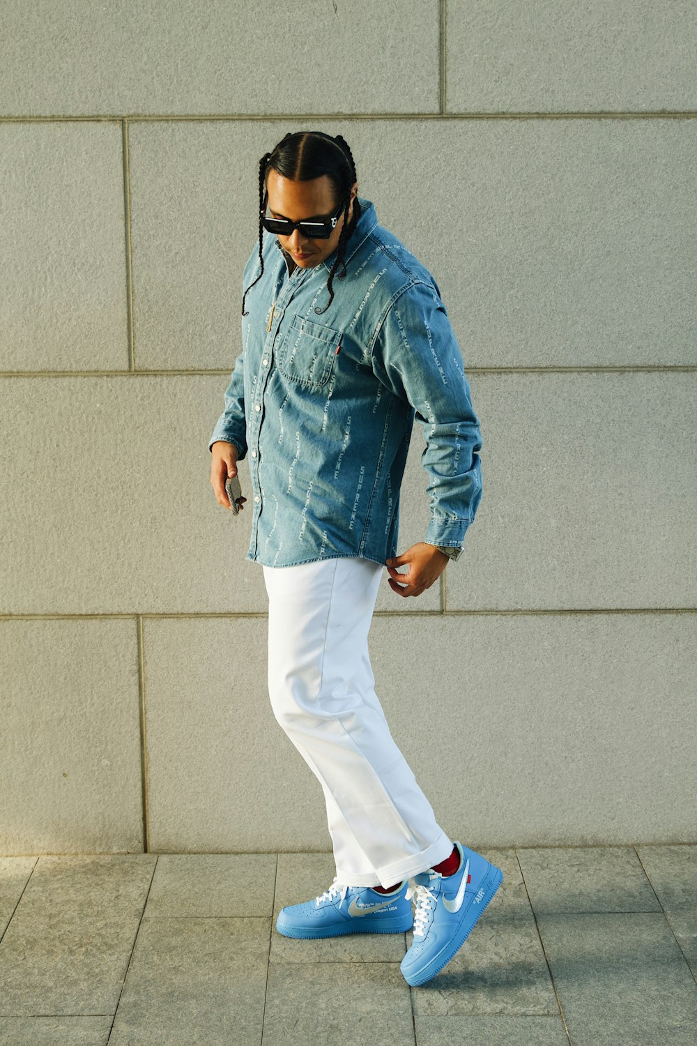 Un uomo con una camicia di jeans e pantaloni bianchi sta camminando foto –  Moda Immagine gratuita su Unsplash