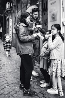 A candid shot of a family enjoying takeaway meals together on a shaded bench near the store.
