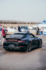 A sleek sports car parked beside a smiling influencer shaking hands with a brand representative.