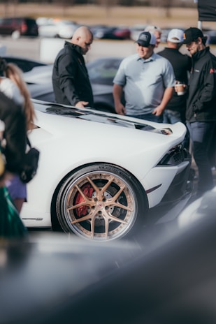 A group of automotive enthusiasts discussing vehicle features.