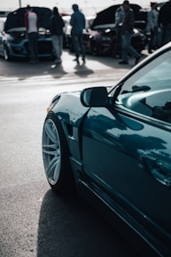 A close-up of a car enthusiast capturing a stunning vehicle at a car show, showcasing their love for automotive culture.