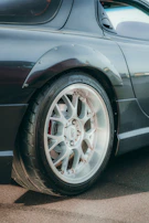 Close-up of a technician performing a precise laser wheel alignment on a sleek vehicle.