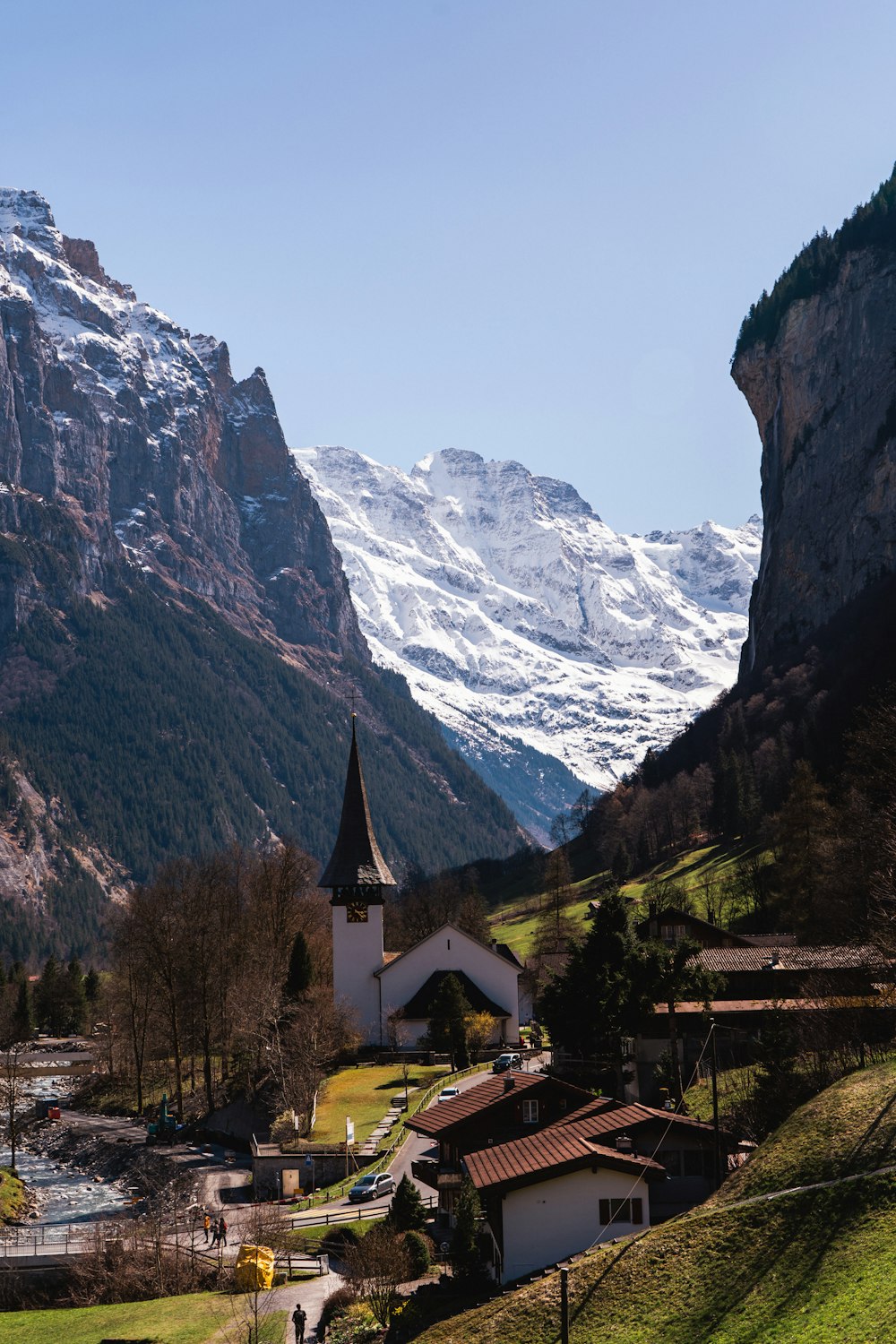 a church in the middle of a valley with mountains in the background