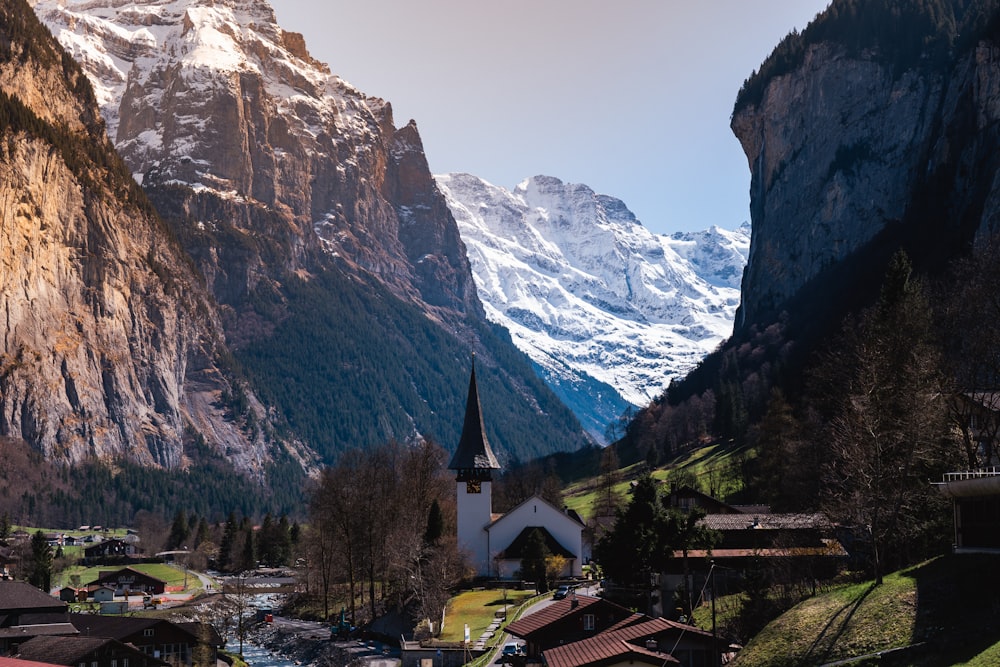 a village in the mountains with a church in the foreground