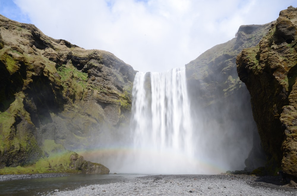 a waterfall with a rainbow in the middle of it