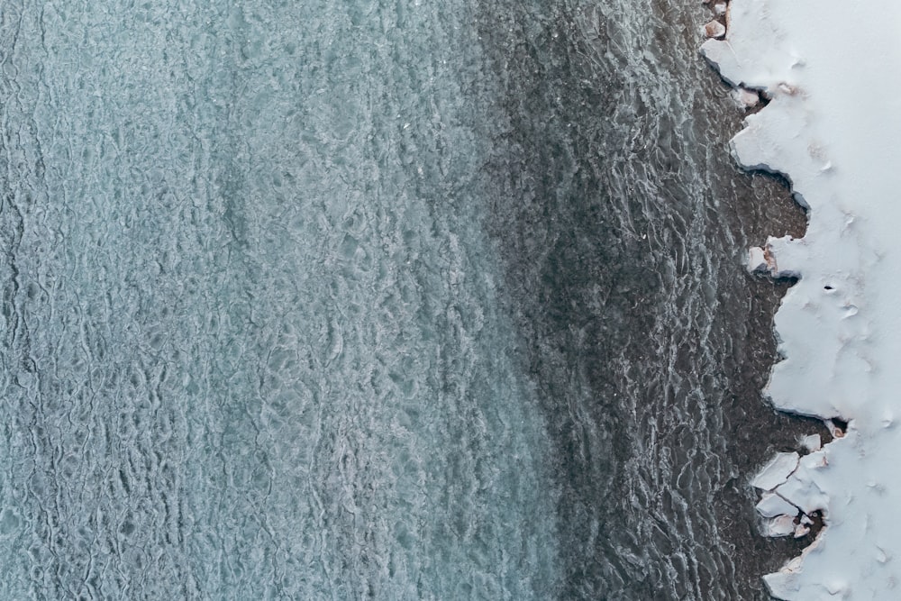 an aerial view of a body of water covered in snow