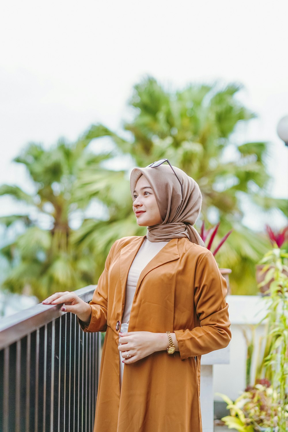 a woman standing on a bridge wearing a hijab