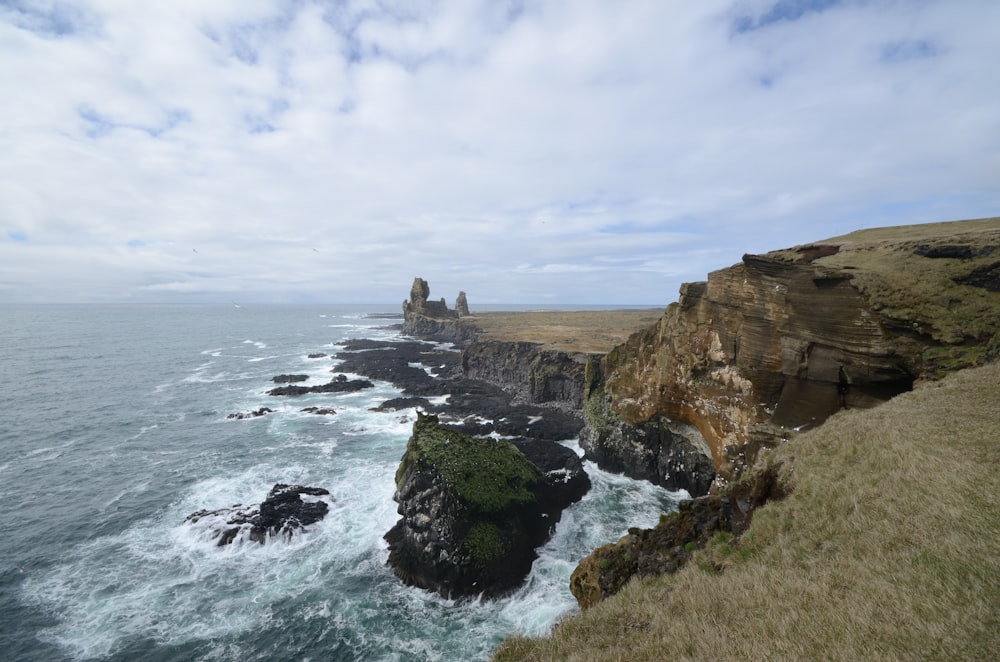 a large body of water next to a rocky cliff