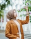 a woman in a hijab is holding a flower