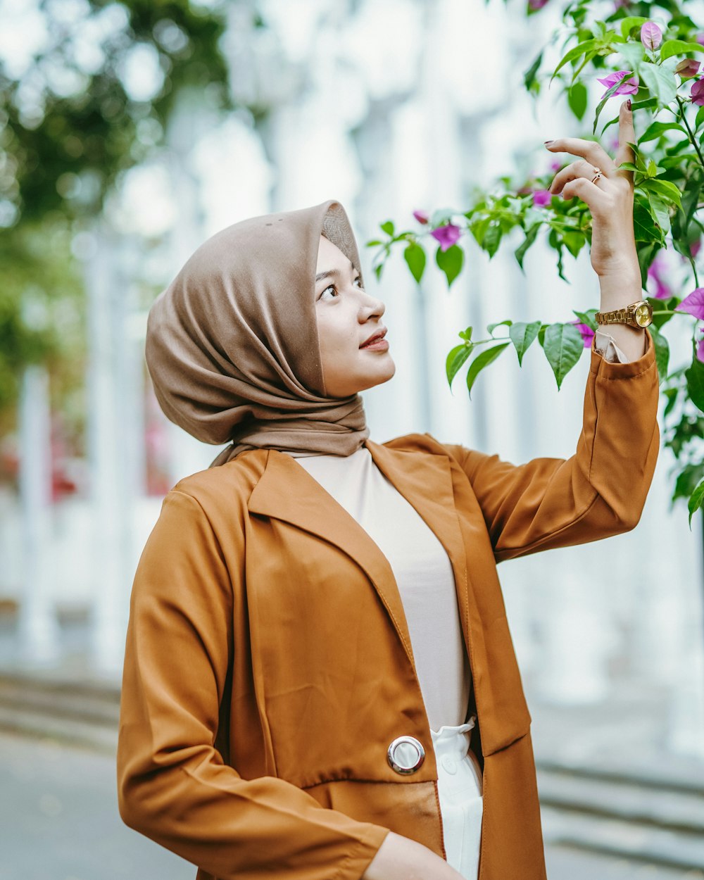 Eine Frau mit Hijab hält eine Blume in der Hand