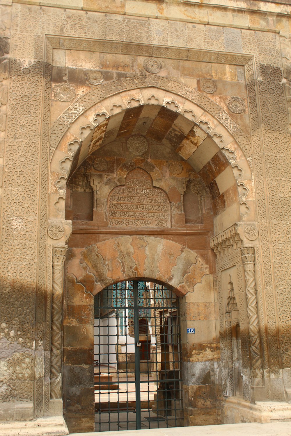 a gated entrance to a building with a statue in the background