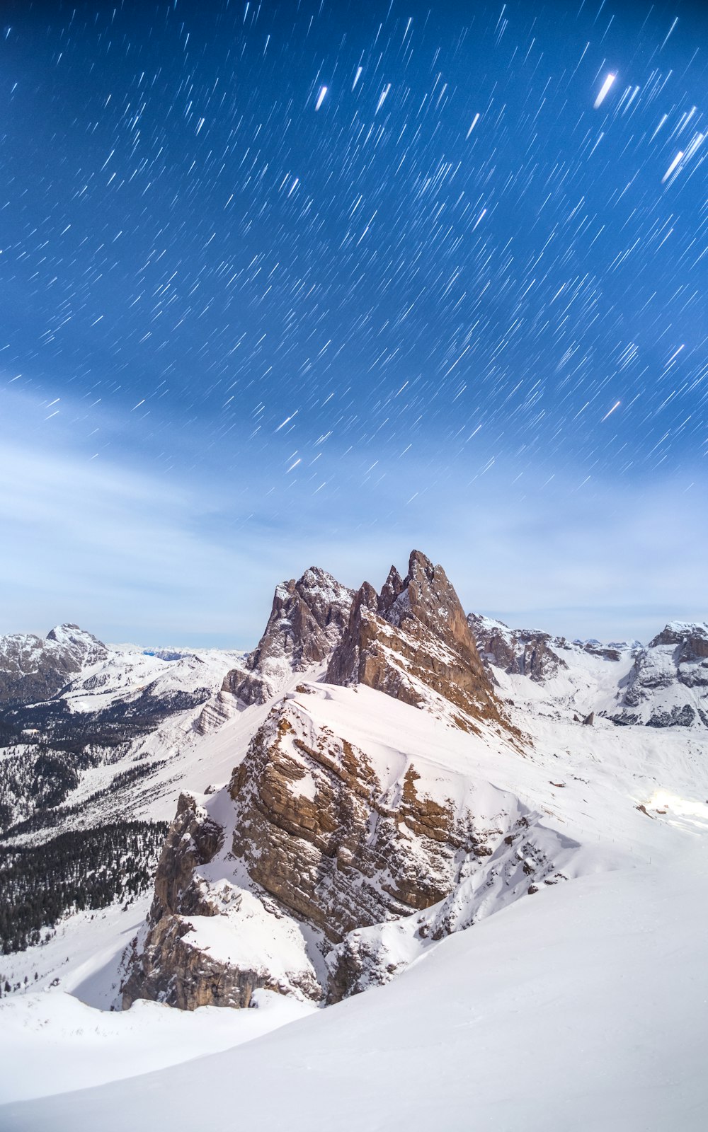 a snow covered mountain with stars in the sky