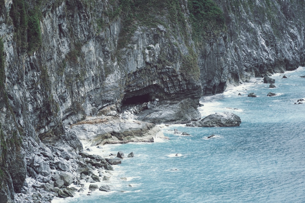 a large body of water next to a rocky cliff