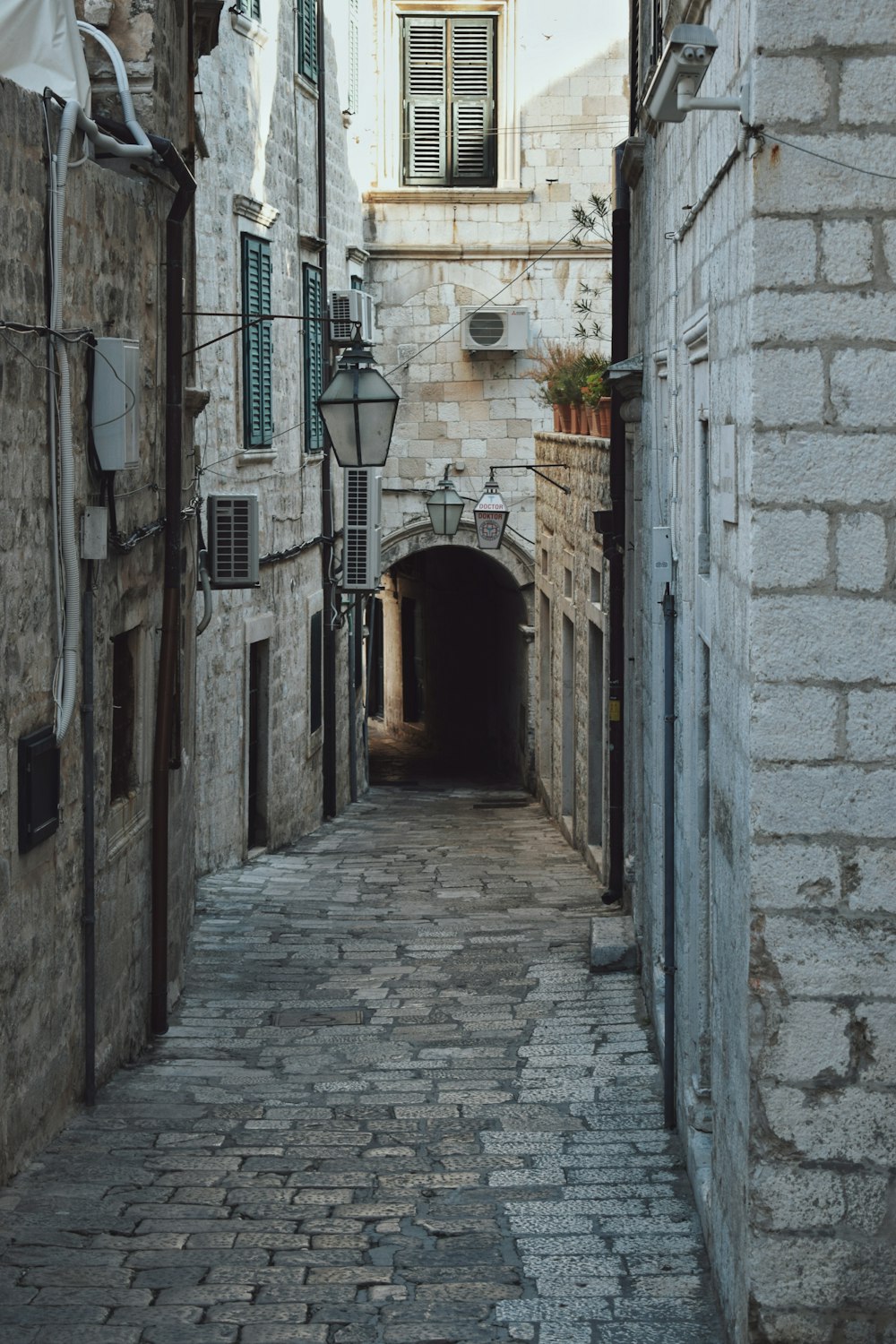 a narrow alley way with a stone building in the background