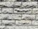 A close-up view of a textured stone wall featuring rectangular blocks stacked with visible rough and rugged surfaces. The stones display a natural, uneven alignment, adding to the rustic appearance.
