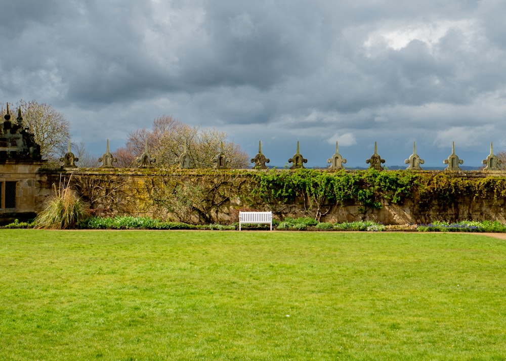 a bench sitting in the middle of a lush green field