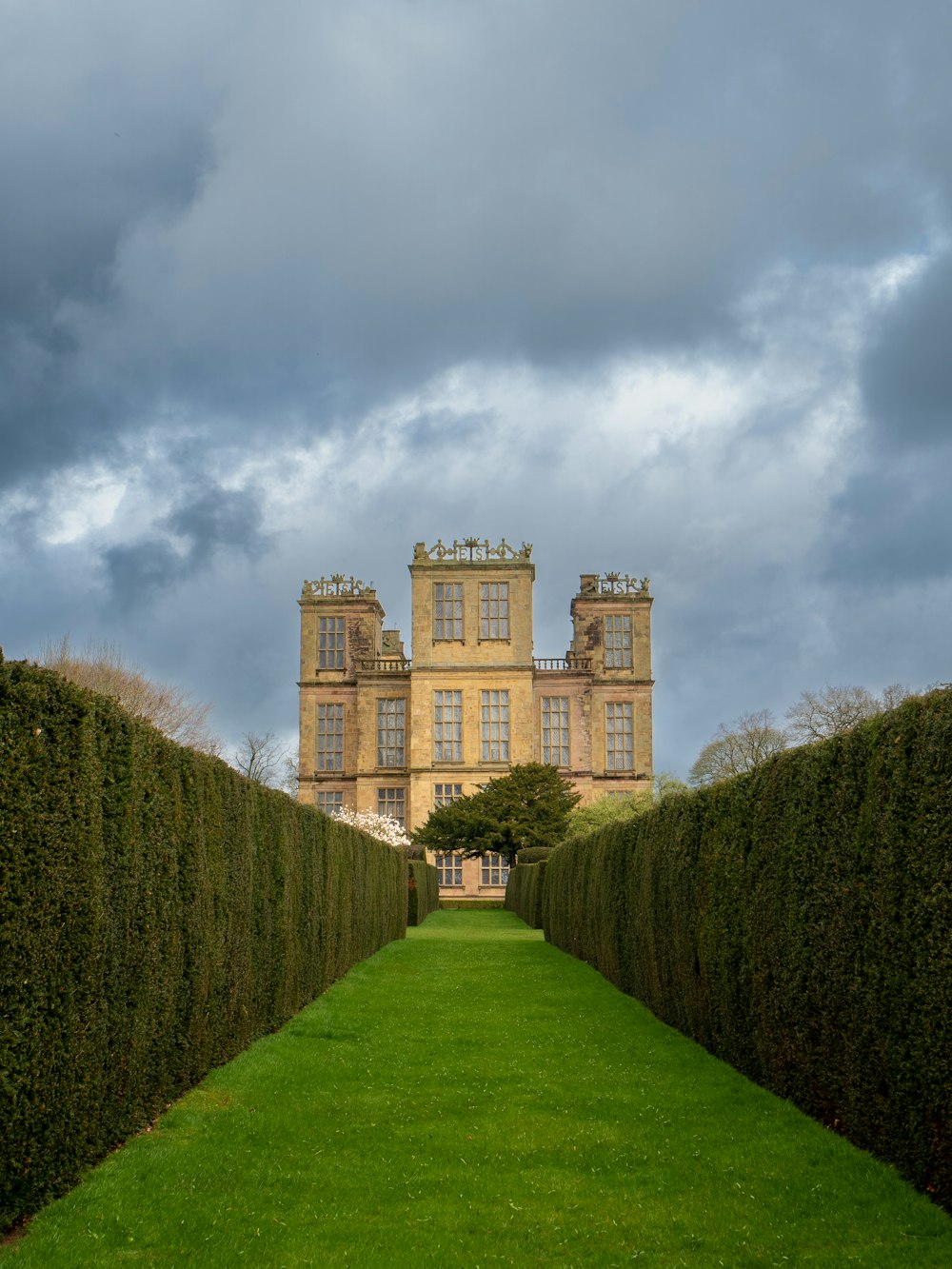 a very tall building with a very long green lawn