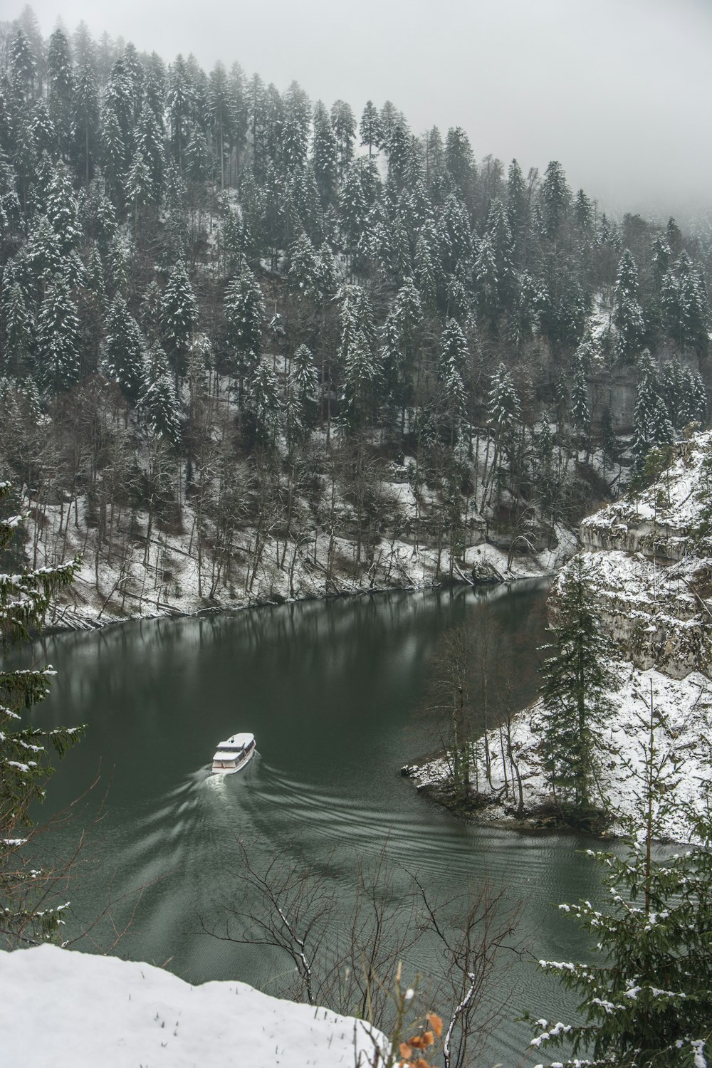 Un bateau est dans l’eau entouré de neige