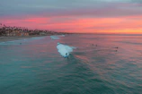 Sunset view over the beach in Sayulita with surfers catching waves and palm trees swaying.