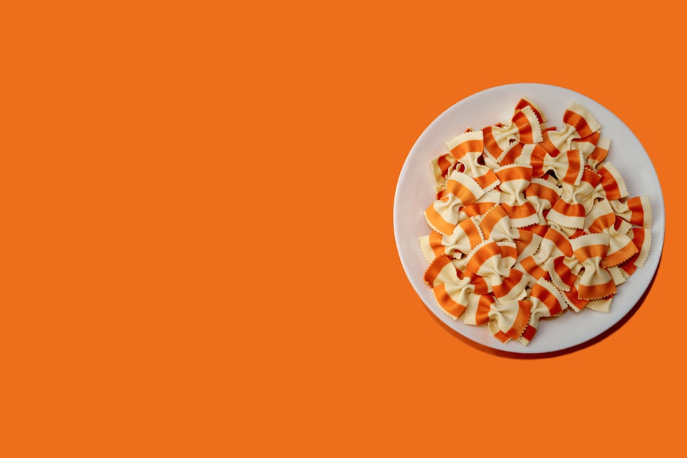 a plate of sliced apples on an orange background