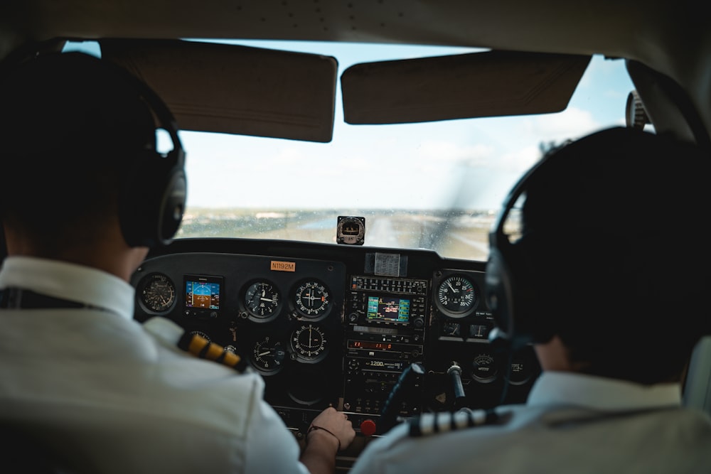 a couple of pilots sitting in the cockpit of a plane