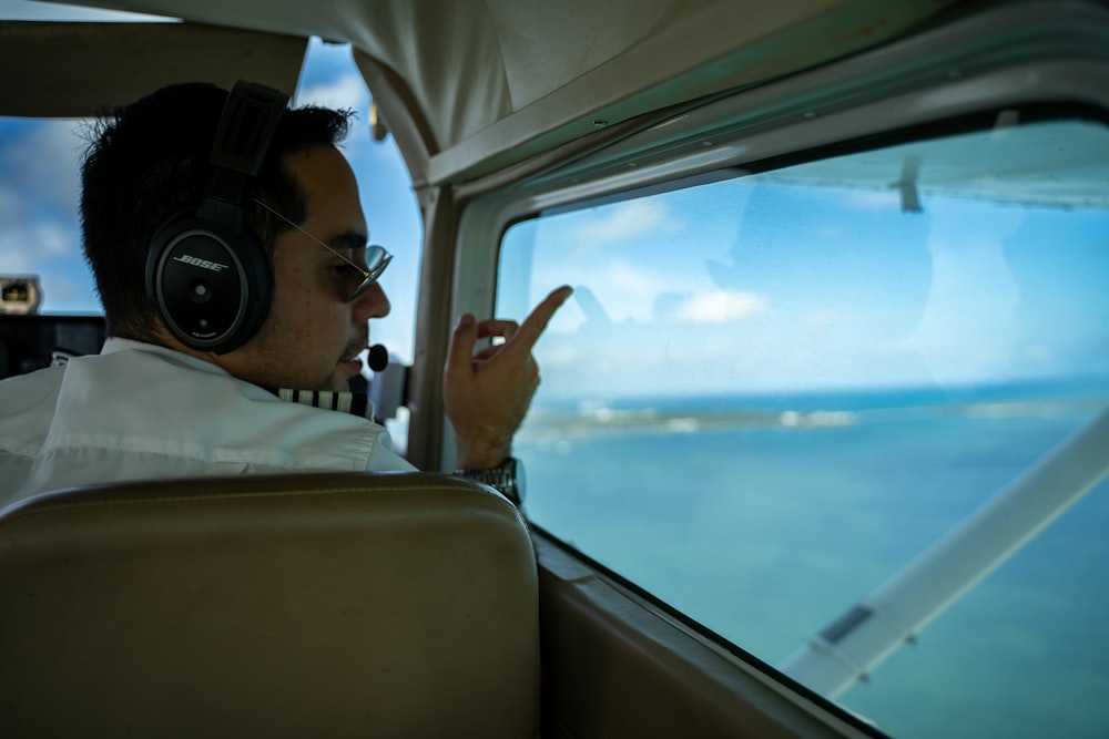 Un hombre sentado en un avión con auriculares puestos