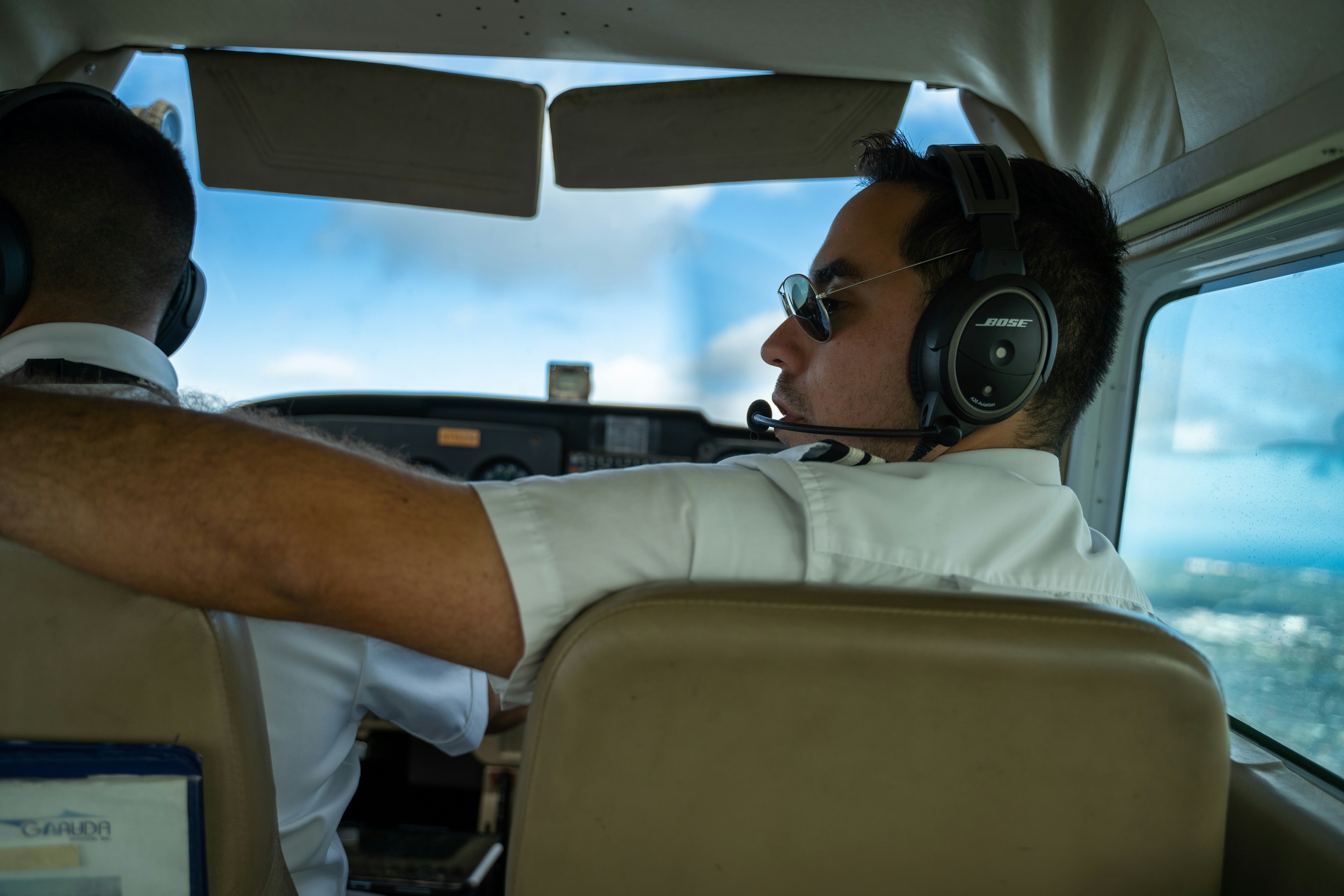 a man sitting in the cockpit of a plane wearing headphones