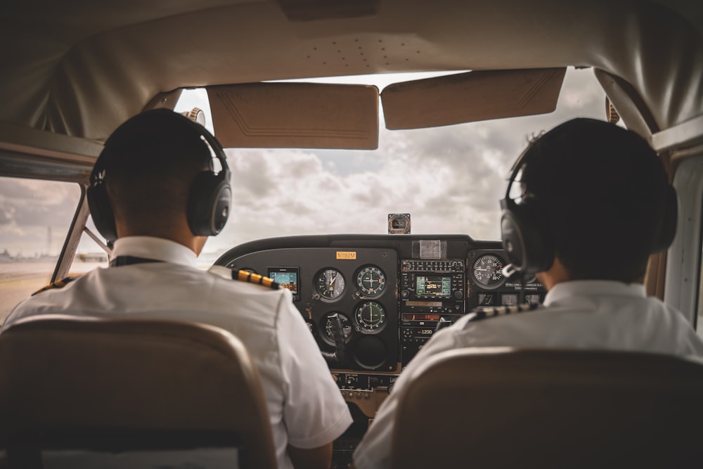 a couple of pilots sitting in the cockpit of a plane