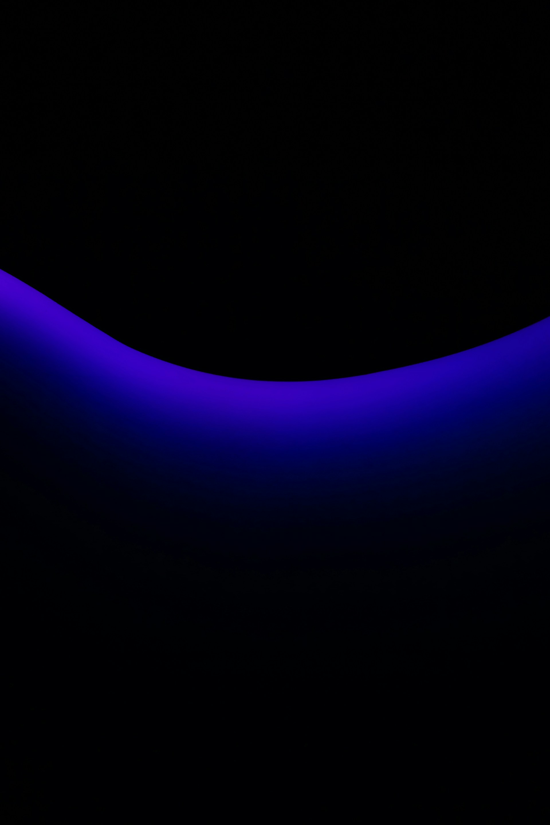 a black background with a blue curved object