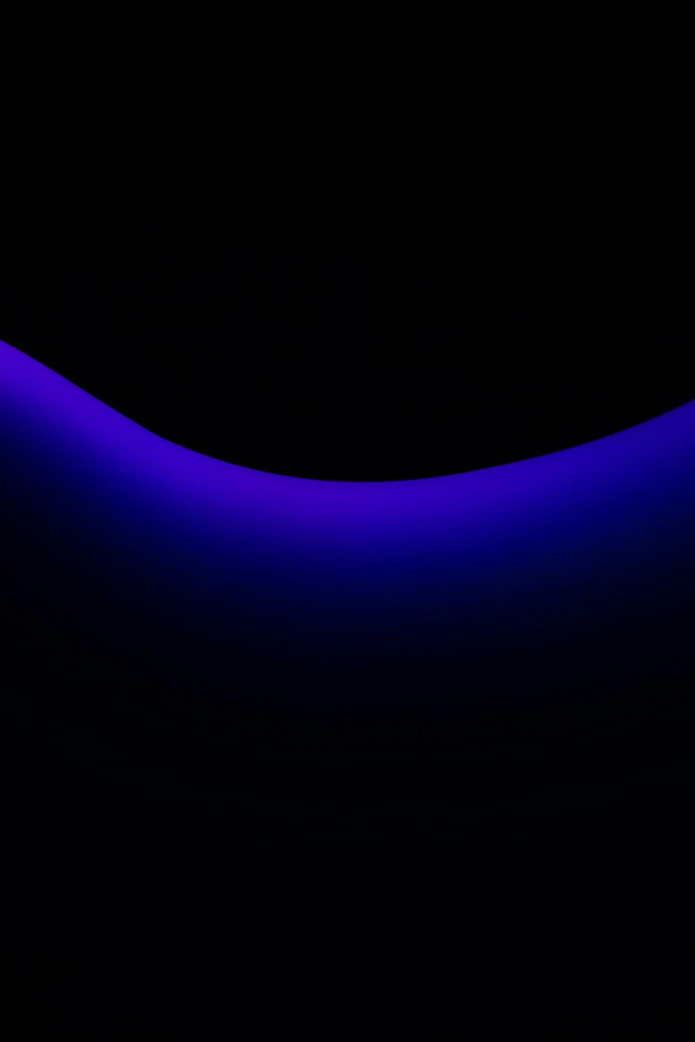 a black background with a blue curved object