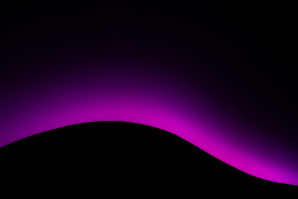 a black and purple background with a hill