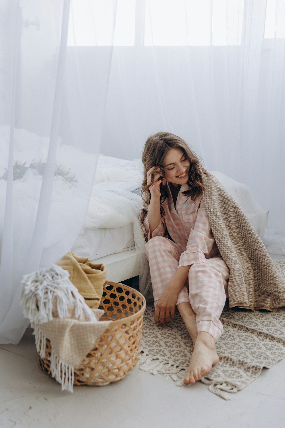 a woman sitting on the floor talking on a cell phone