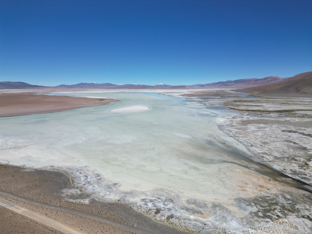 an aerial view of a body of water surrounded by mountains