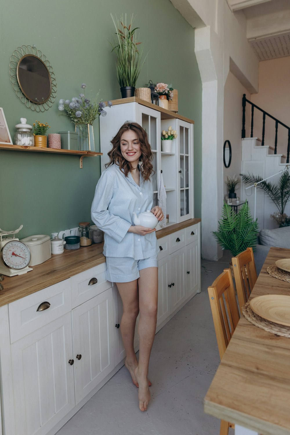 a woman standing in a kitchen next to a table