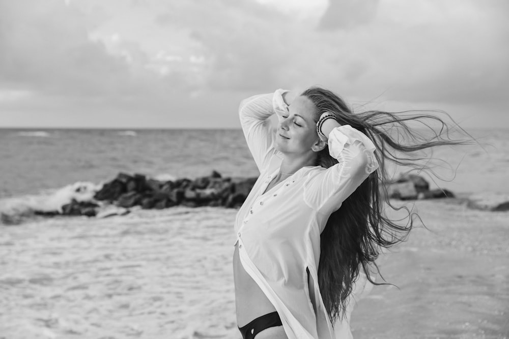 a woman standing on top of a beach next to the ocean